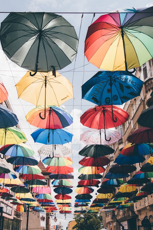 Free A Low Angle Shot of Colorful Umbrellas Hanging on the Street Stock Photo