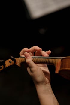 Detailed view of fingers playing a violin during a live performance.