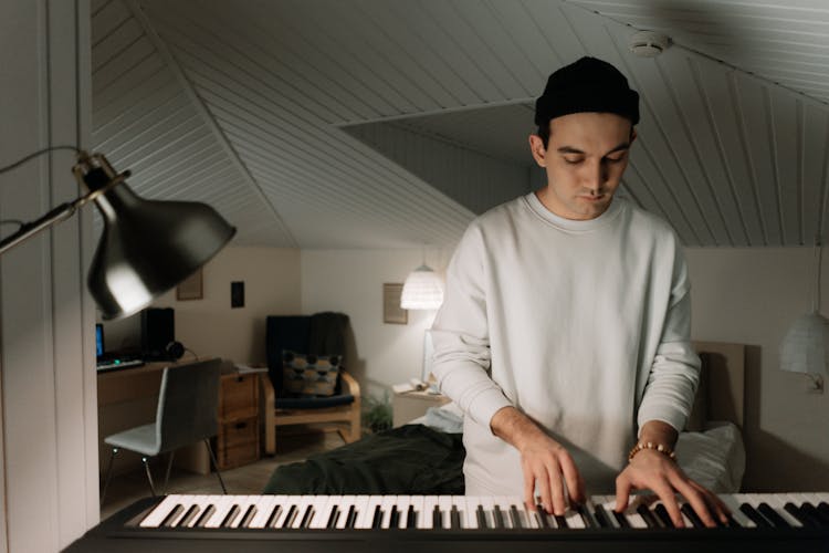 A Man In White Sweater Playing Keyboard