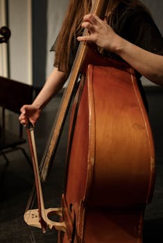 A female cellist skillfully plays her cello during a performance indoors.