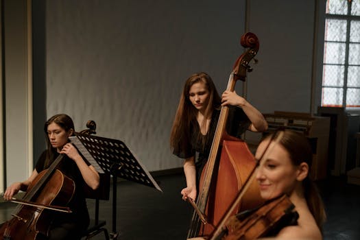 A trio of female musicians playing string instruments in a chamber music setting.
