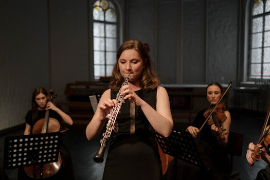A woman playing the oboe during a classical music concert indoors.