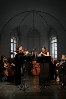 Orchestra performing classical music in a church setting, showcasing a variety of instruments.