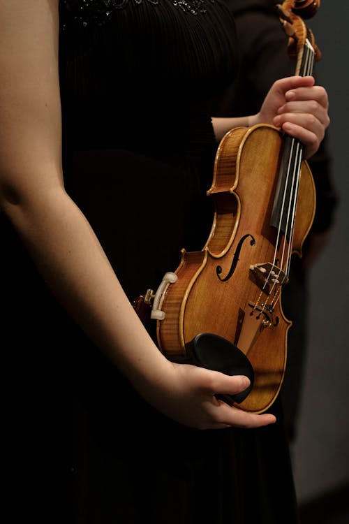 Close-Up Shot of a Person Holding a Violin