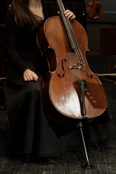 A woman playing the cello on stage during a classical music concert, showcasing musical elegance.