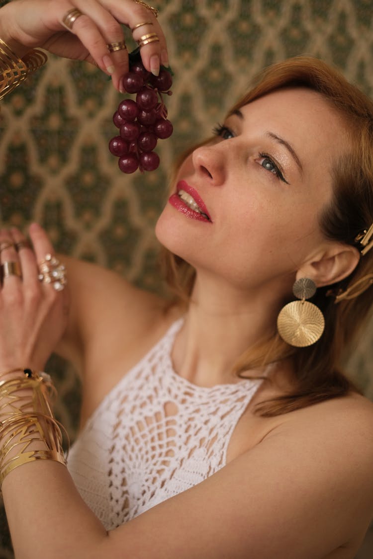 Alluring Woman With Trendy Earrings Enjoying Sweet Grapes