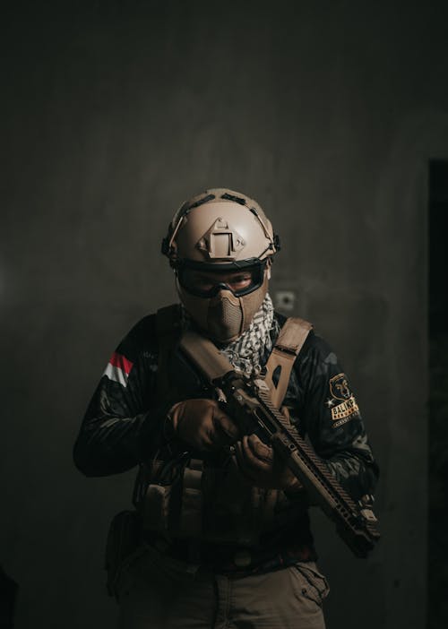 A Man Wearing a Military Uniform Holding a Firearm
