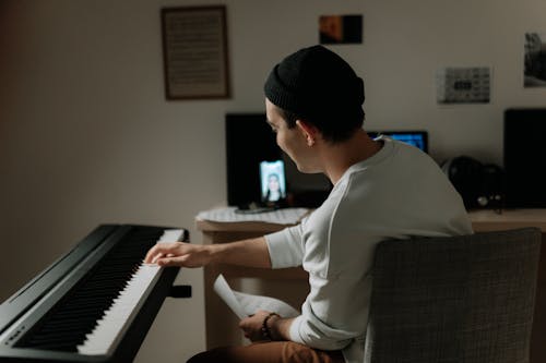 A Man in White Sleeves Playing Piano