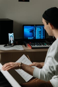 Musician engaged in a remote piano session with video call on phone.