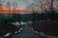 白俄罗斯维捷布斯克河岸上，迷人的日落景色映衬着树木的轮廓和宁静的小路