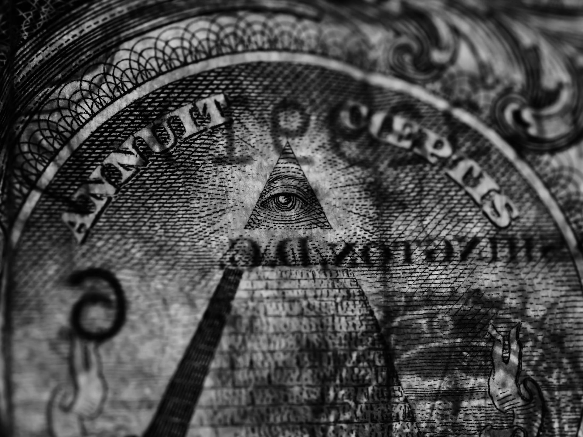 Detailed grayscale image focusing on the Eye of Providence from a US dollar bill.