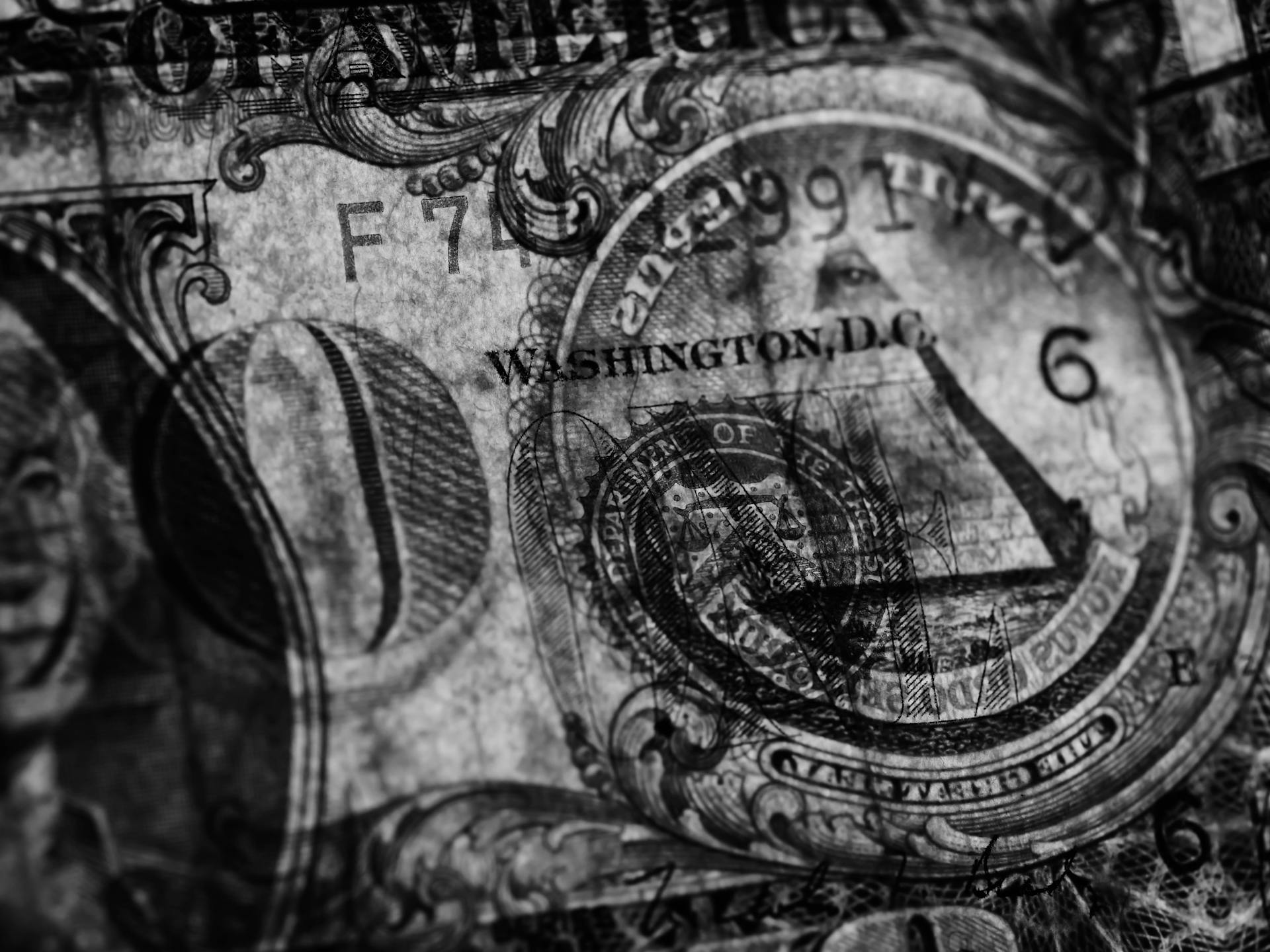 Detailed black and white close-up of a dollar bill showcasing intricate patterns and symbols.