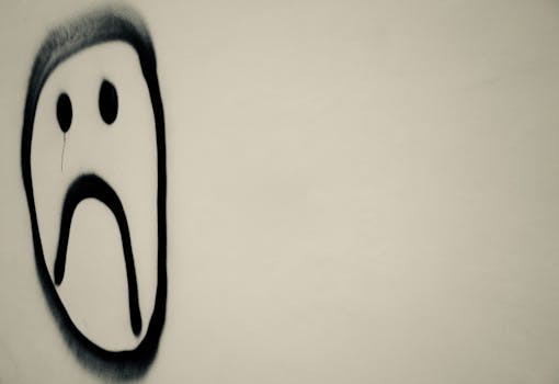 一张单色照片中，墙上涂鸦着悲伤的面孔，象征着城市的情感