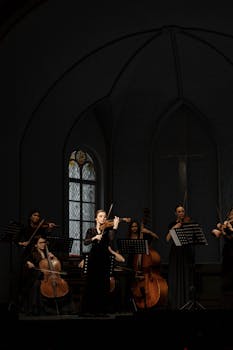 A classical string ensemble performing in a church setting, highlighting violins and cellos.