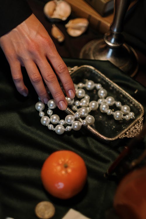 Person Touching White Pearls