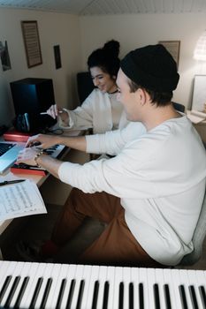 Two friends creating music together in a cozy home studio environment.
