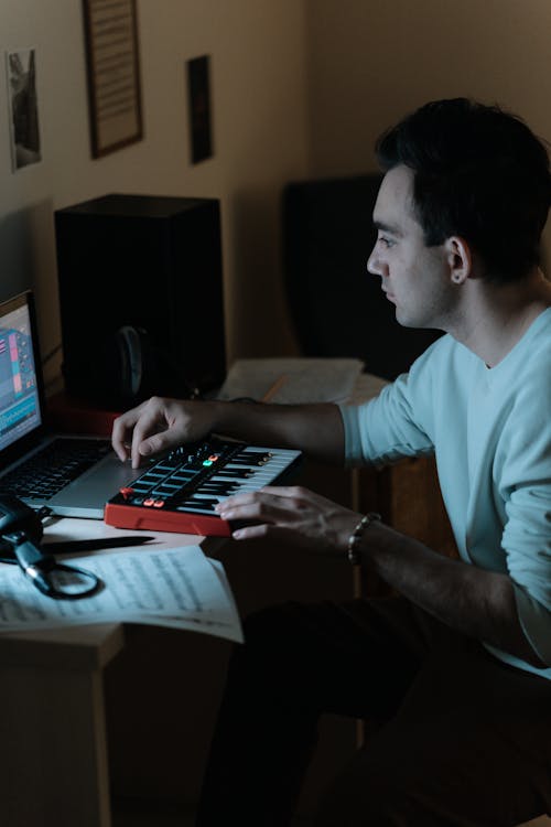 A Man in using Laptop Recording Music