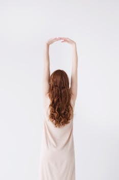 woman in beige dress stretching her hands