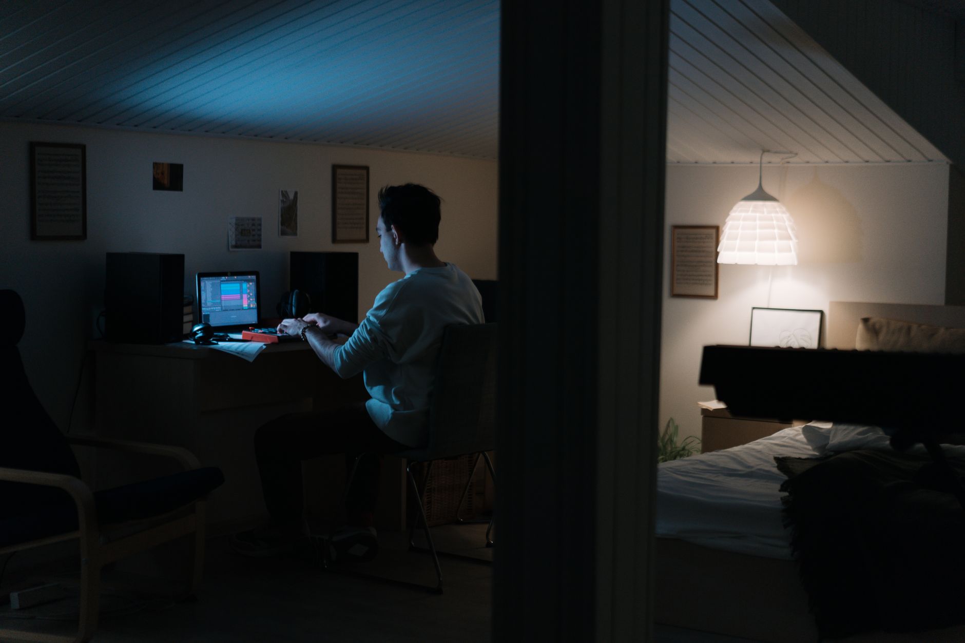 A dimly lit home office with racing odds charts, calculator, and coffee beside a laptop