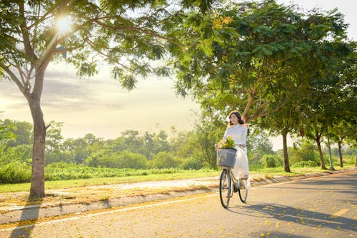 A Woman in White Dress Riding a Bike