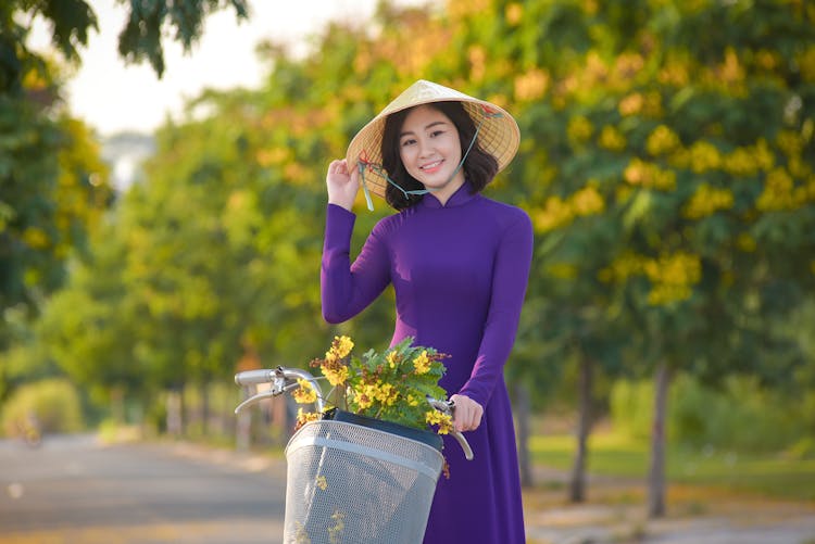 A Woman In Purple Dress Riding A Bike