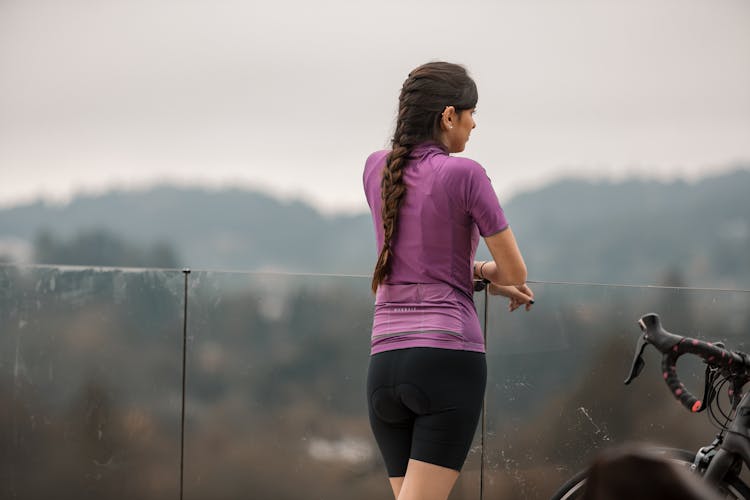 Unrecognizable Woman In Sportswear On Balcony Near Bike