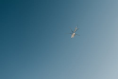Helicopter flying in blue cloudless sky