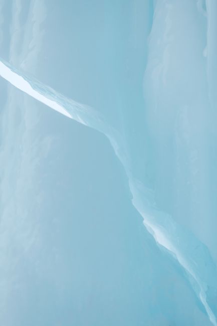 Close-up of a frozen ice surface with natural textures and light reflections.