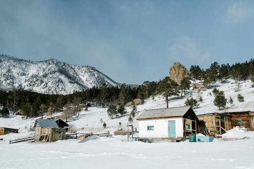 White and Brown House Near Snow Covered Mountain