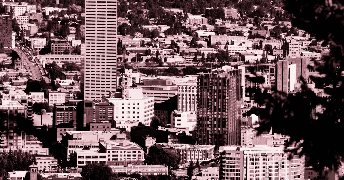 Dramatic sepia cityscape view with tall skyscrapers and dense urban architecture surrounded by trees.