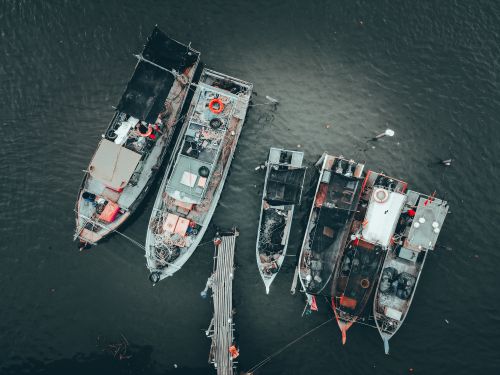 Free Top view of modern fishing boats with nets and fishing tackle moored on pier at seashore Stock Photo