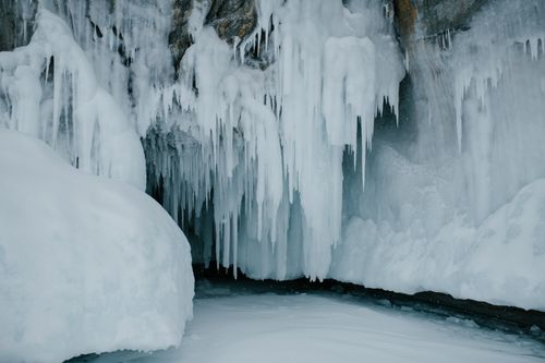 Free Captivating frozen icicles hang from a cave wall, epitomizing the heart of winter. Stock Photo