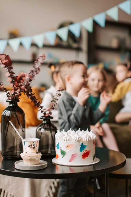 Free Child's birthday party with cake and cupcakes on table. Stock Photo