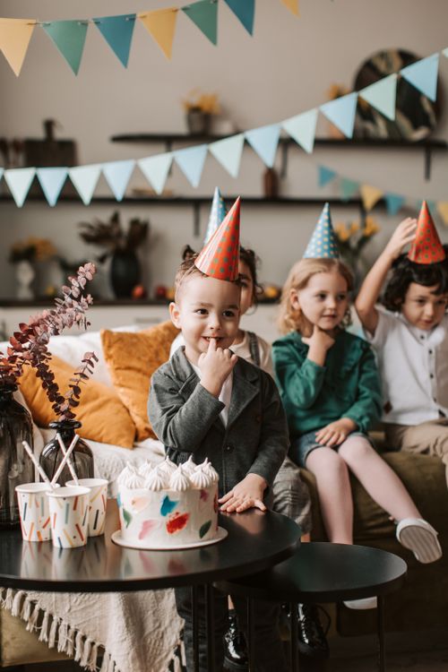 Free Group of kids enjoying a birthday party at home with decorations and cake. Stock Photo