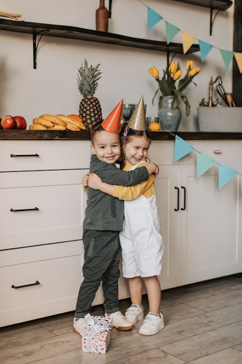 Boy in Gray Jacket Hugging a Girl in White and Yellow Dress