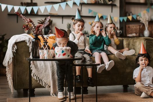 A joyful children's birthday party with kids in party hats, cake, and festive decorations.