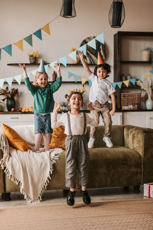 Free Joyful children celebrating a birthday indoors, surrounded by colorful decorations and festive vibes. Stock Photo