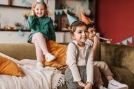 Girl in Green Dress Sitting on Brown Couch