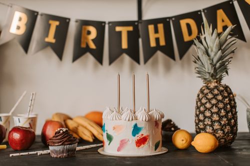 Free A colorful birthday cake with fruits and festive decorations on a table indoors. Stock Photo