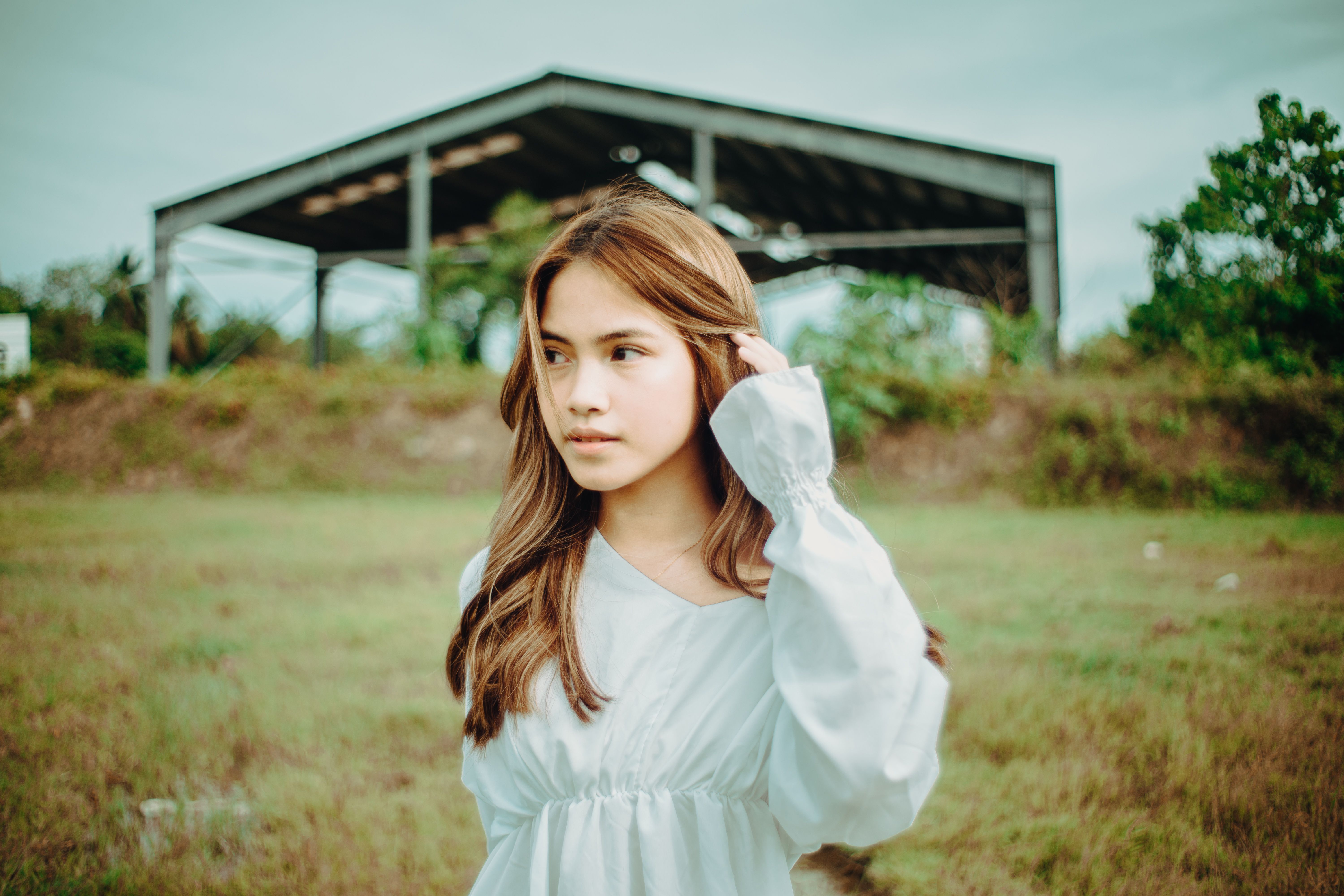 Woman in White Long Sleeve Top Standing on Green Grass Field · Free ...