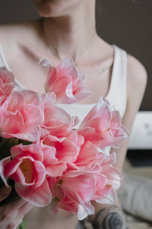 A Woman in White Tank Top Holding Pink Rose Bouquet