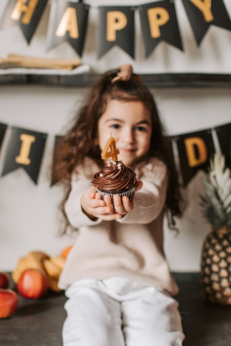 A Girl Holding A Cupcake