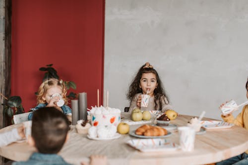 Free Children Sitting on the Table with Birthday Cake Stock Photo