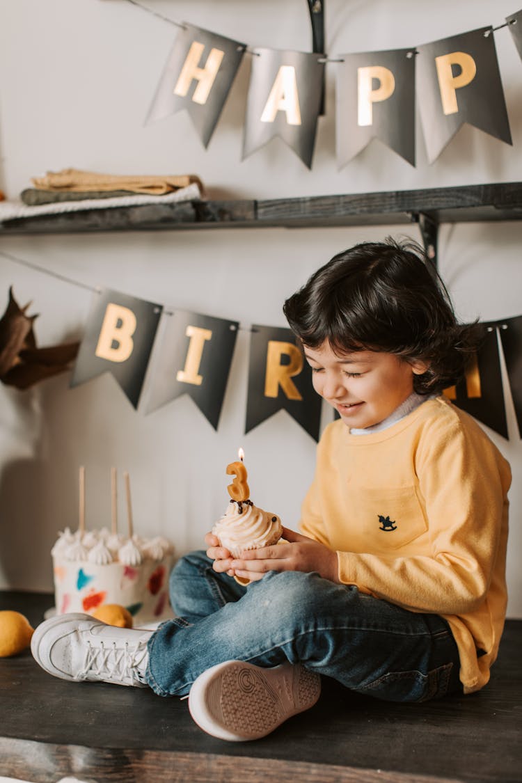 A Boy Holding A Cupcake