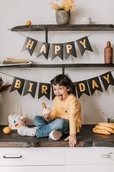 Happy child with cake and decorations during a birthday celebration.