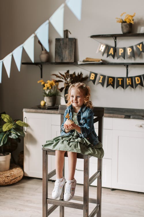 A Girl Sitting while Holding a Cupcake