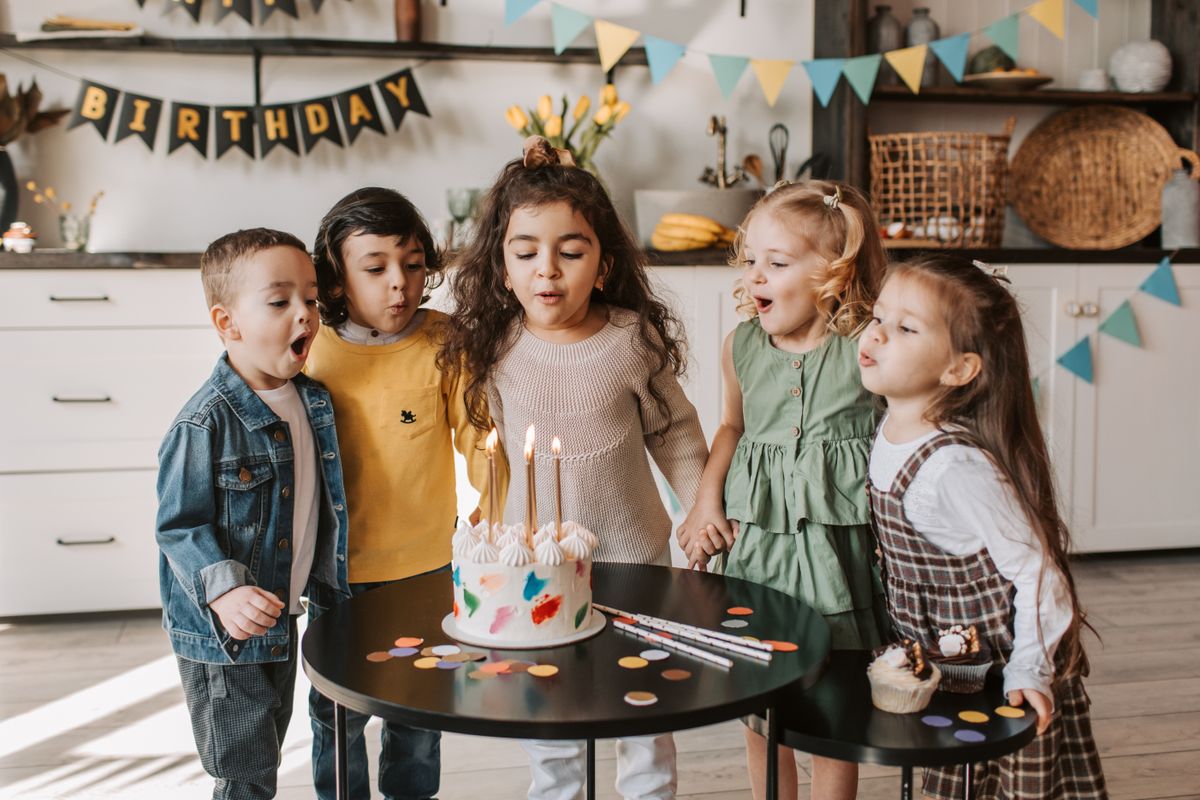 Kids celebrating a birthday, blowing out candles on a cake