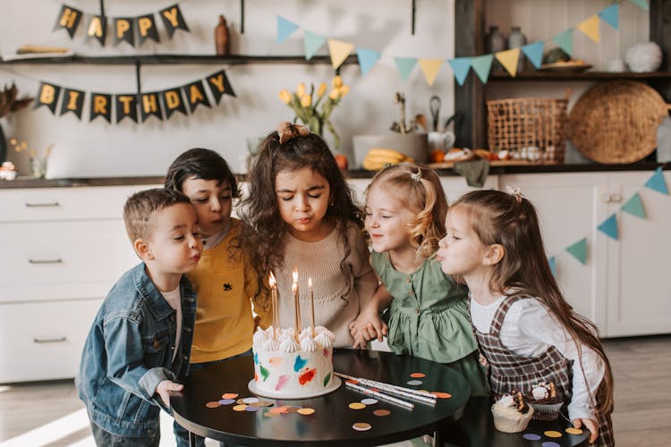 Photograph Of Children Blowing Cake Candles