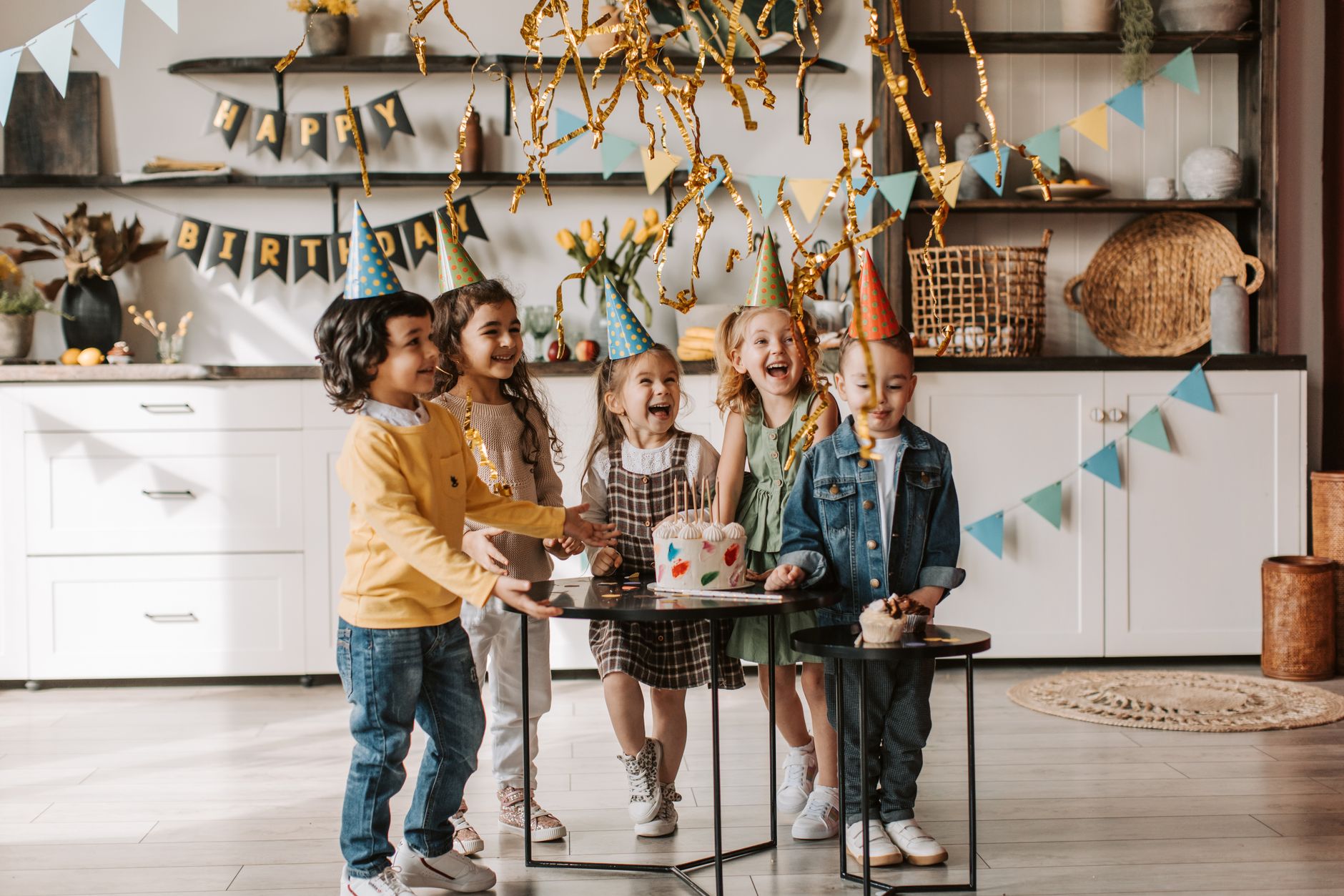 birthday party decoration ideas egypt — Children enjoying a fun birthday party indoors with cake and decorations, full of lau