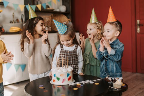 Free Smiling Boys and Girls Standing by Birthday Cake on Table Stock Photo